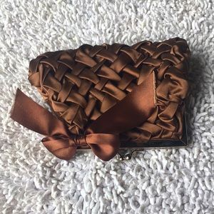 Small bronze satin evening bag with criss cross design, bow and silver hardware